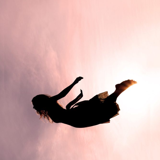 Silhouette,Of,A,Young,Woman,Falling,Through,The,Pink,Sky.