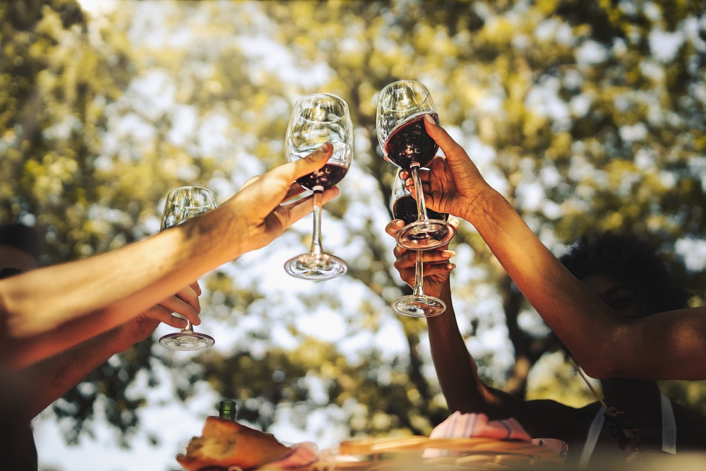 Group,Of,Young,Friends,Celebrating,Friendship,Rising,Hands,Holding,Red
