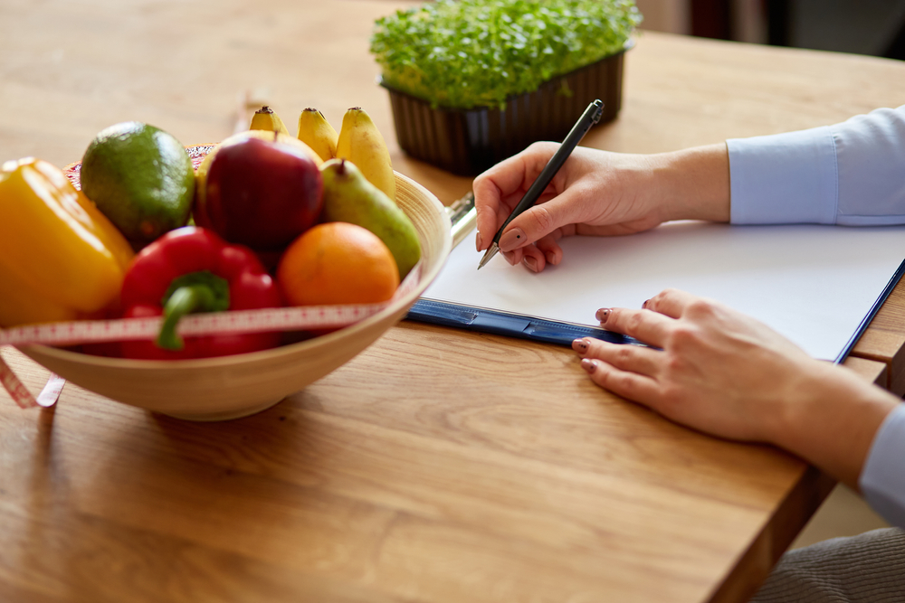 Nutritionist,,Dietitian,Woman,Writing,A,Diet,Plan,,With,Healthy,Vegetables