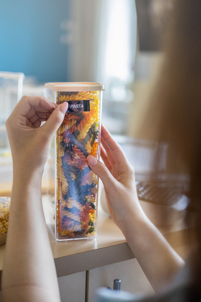Closeup,Female,Hands,Sticking,Label,On,Plastic,Package,With,Pasta.