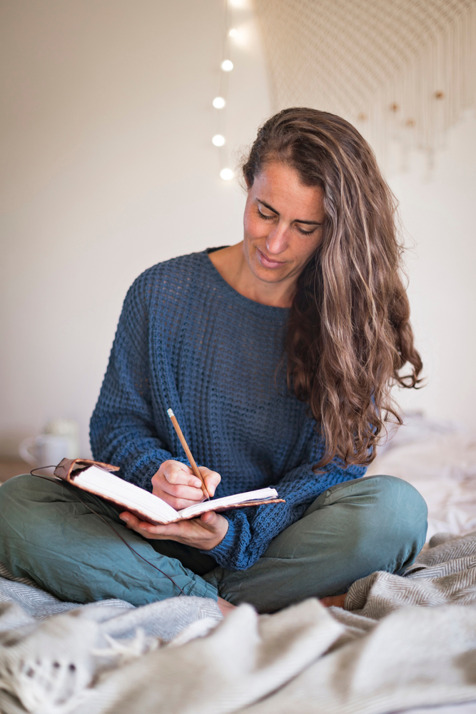 Woman,In,Blue,Sweater,Writing,In,Leatherbound,Journal,Whilst,Sat