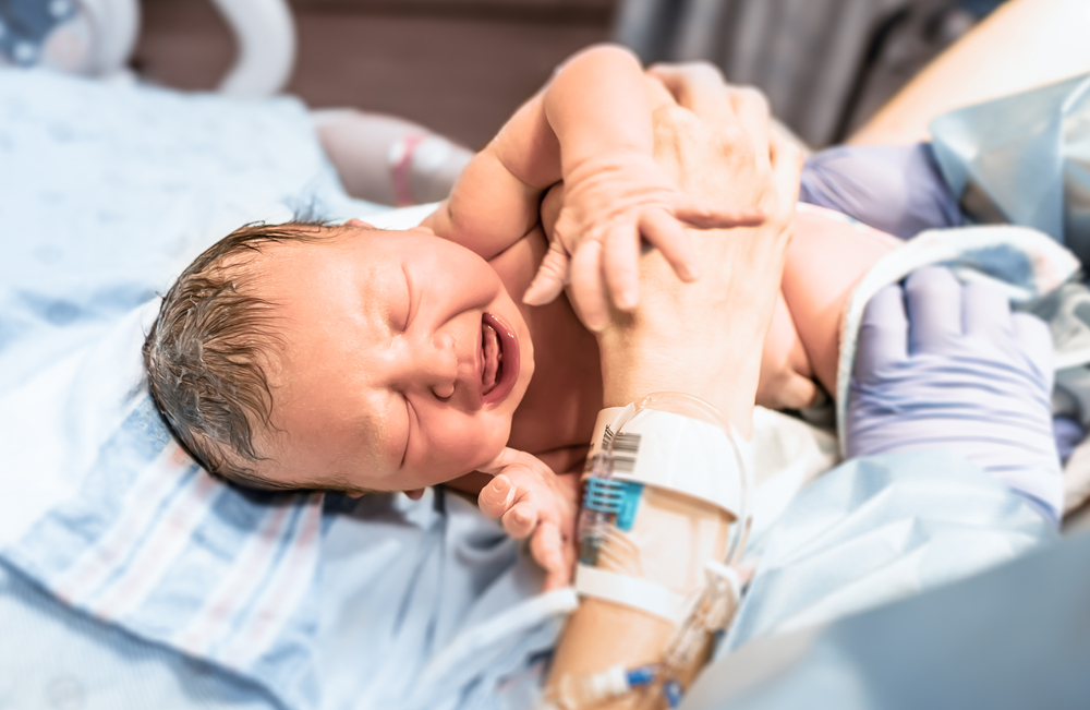 Newborn,Baby,In,Hospital,Moments,After,Birth,Being,Held,In