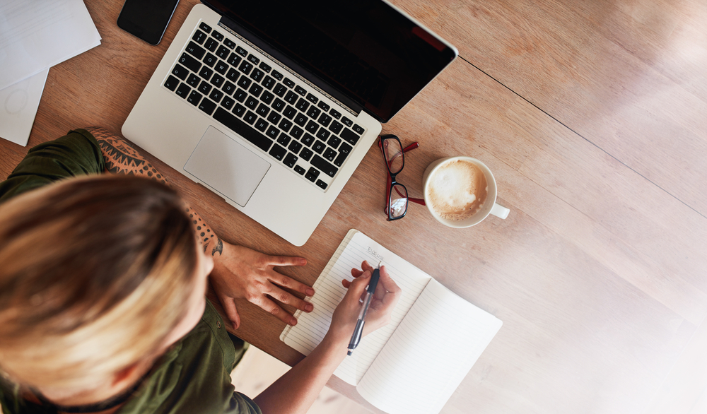 Top,View,Shot,Of,Woman,Sitting,At,Table,With,Laptop
