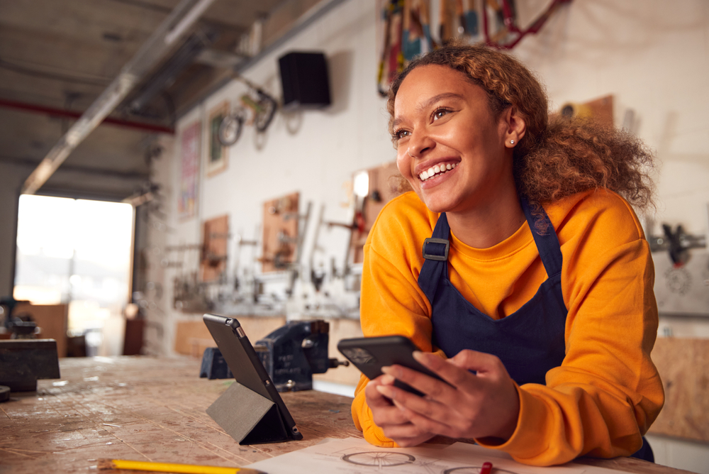 Female,Business,Owner,In,Workshop,Using,Digital,Tablet,And,Holding