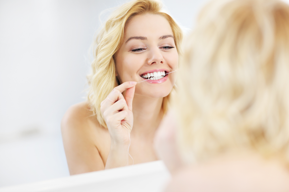 A,Picture,Of,A,Young,Happy,Woman,Using,Dental,Floss