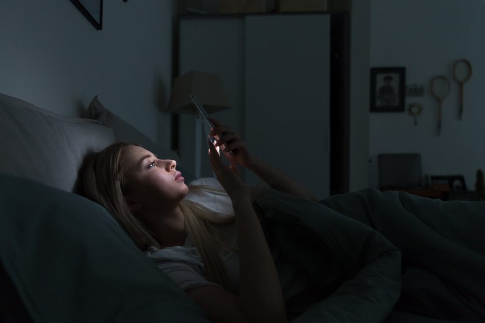 Portrait,Of,Young,Sleepy,Exhausted,Woman,Lying,In,Bed,Using