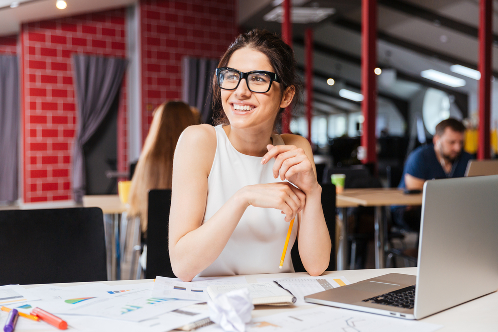 Portrait,Of,Smiling,Pretty,Young,Business,Woman,In,Glasses,Sitting