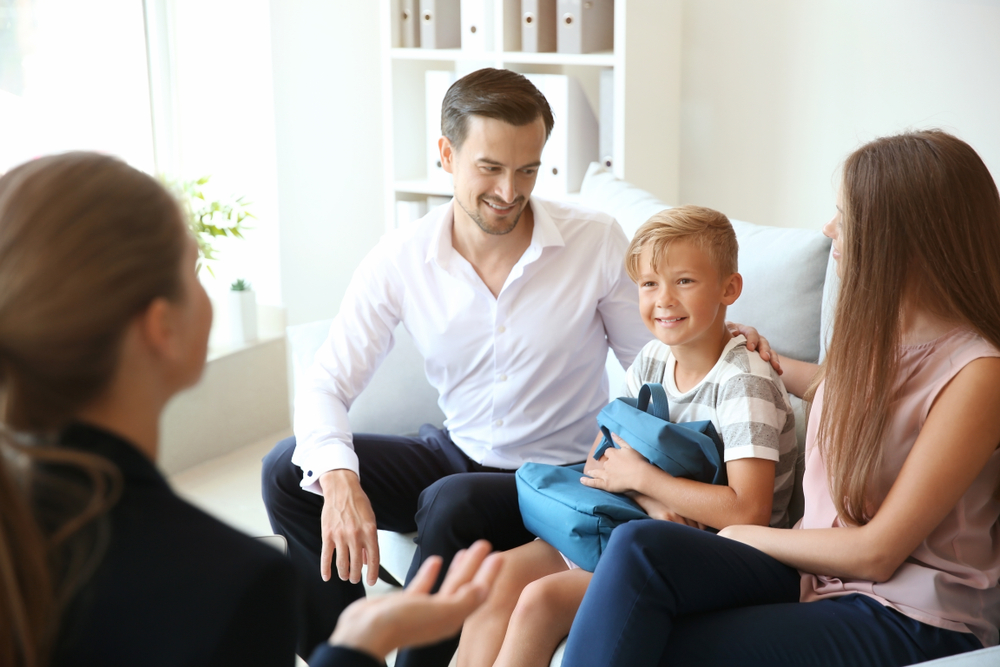 Young,Couple,And,Their,Son,Meeting,With,Headmistress,At,School