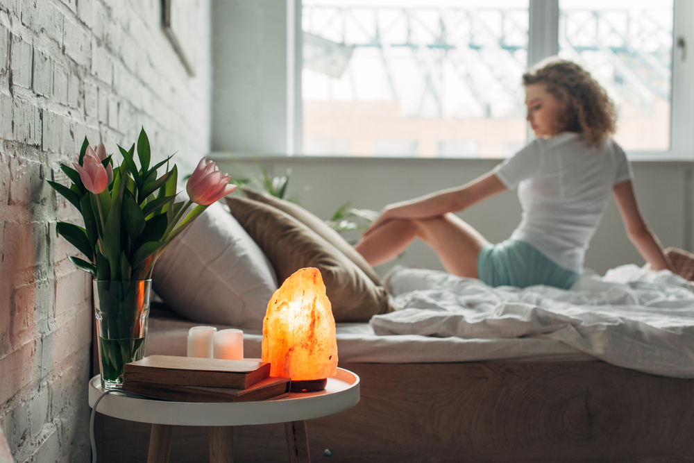 Beautiful,Girl,On,Bed,With,Himalayan,Salt,Lamp,,Flowers,And