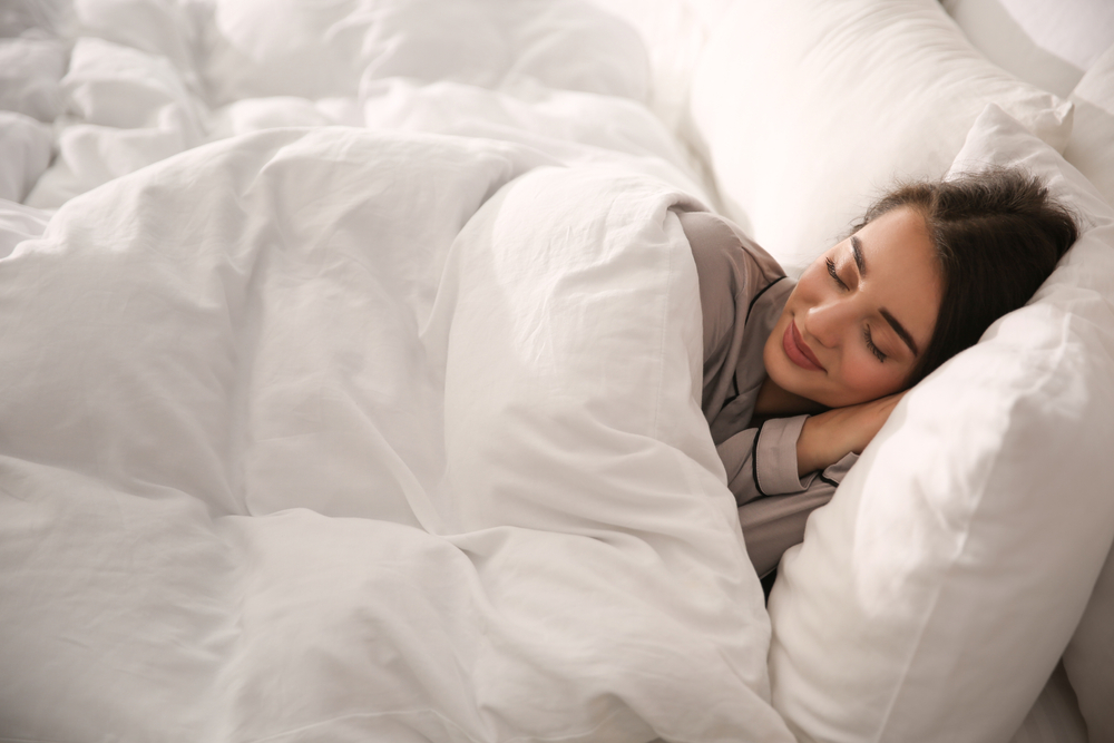 Beautiful,Young,Woman,Wrapped,With,Soft,Blanket,Sleeping,In,Bed