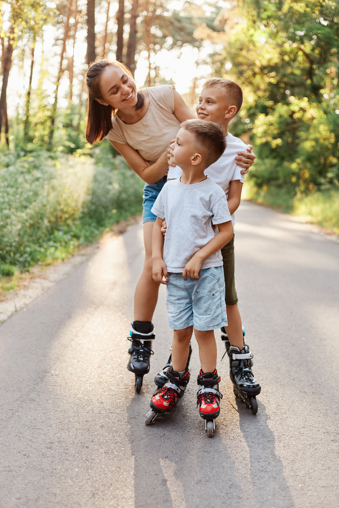 Happy,Smiling,Woman,Roller,Skating,With,Her,Children,In,Summer
