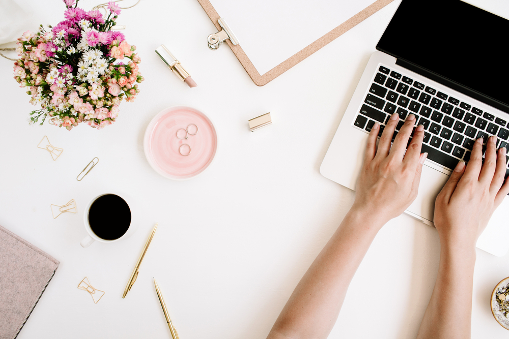 Top,View,Office,Desk.,Workspace,With,Girl's,Hands,,Laptop,,Wildflowers