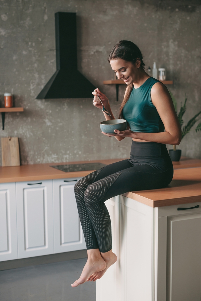 Caucasian,Woman,In,Sportswear,Resting,At,The,Kitchen,After,Exercise