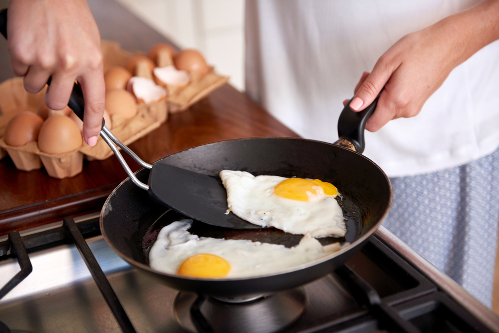 Woman,Preparing,Early,Morning,Eggs,Breakfast,On,Stove,In,Home