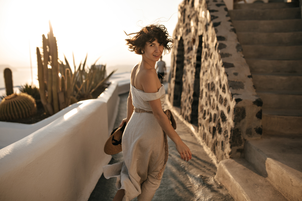 Attractive,Brunette,Woman,In,Beige,Dress,Holds,Straw,Hat,And