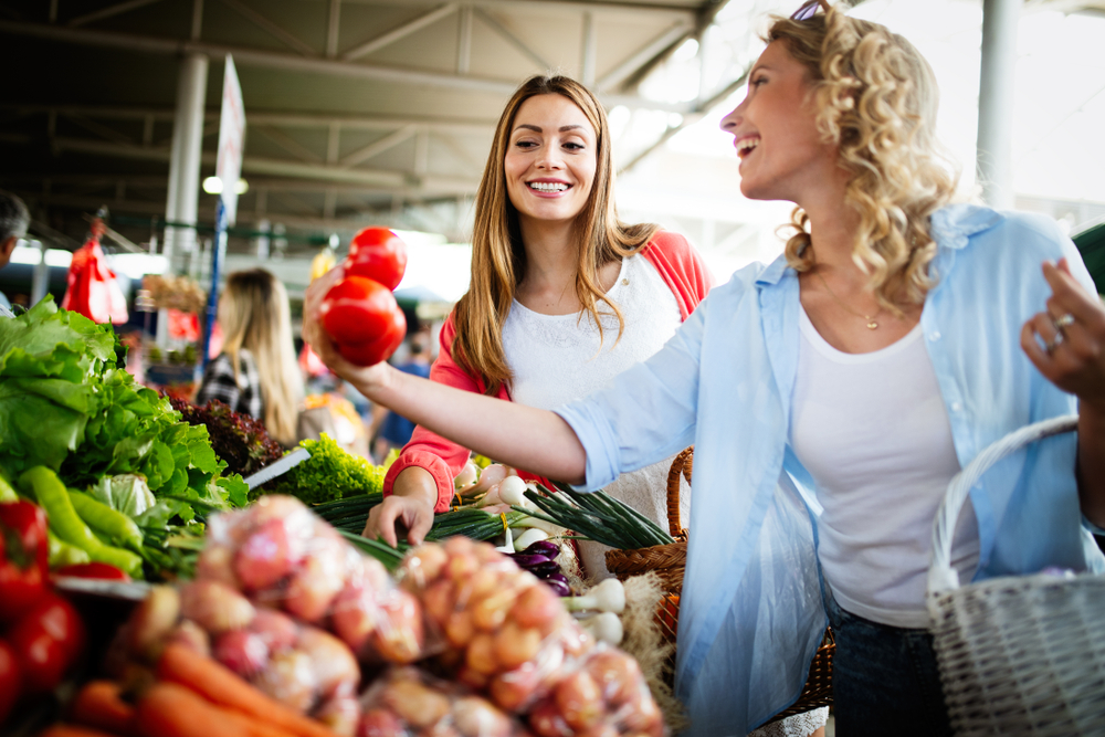 Young,Happy,Women,Shopping,Vegetables,And,Fruits,On,The,Market