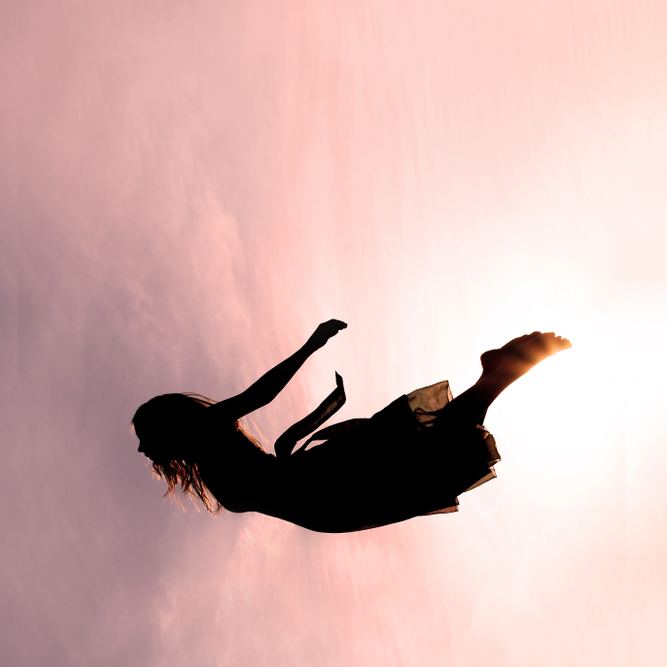 Silhouette,Of,A,Young,Woman,Falling,Through,The,Pink,Sky.