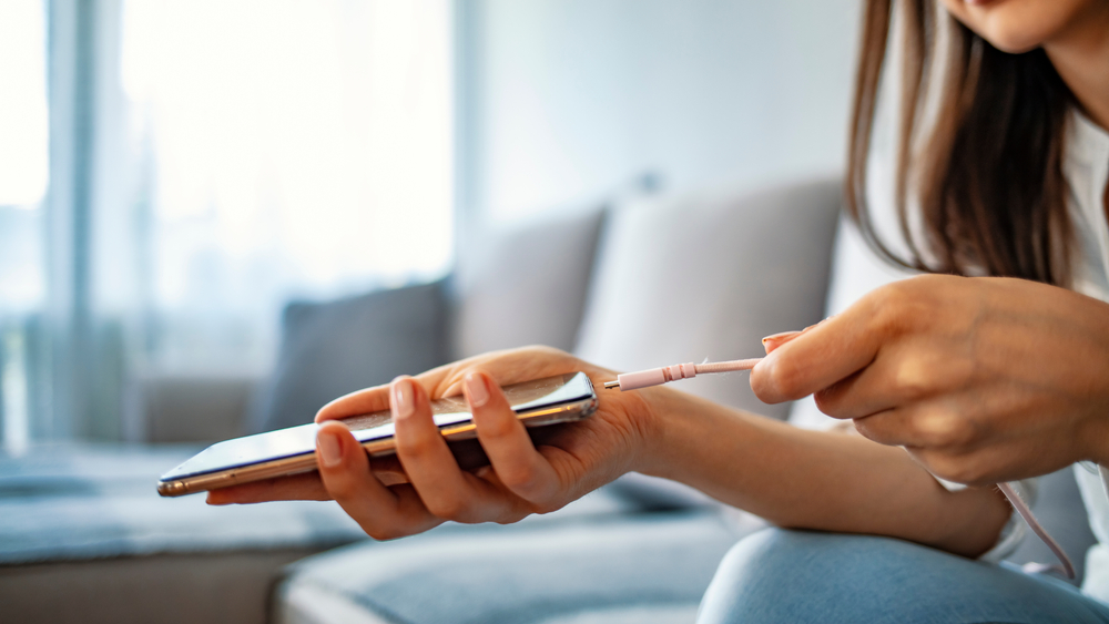 Woman,Hands,Plugging,A,Charger,In,A,Smart,Phone.,Woman