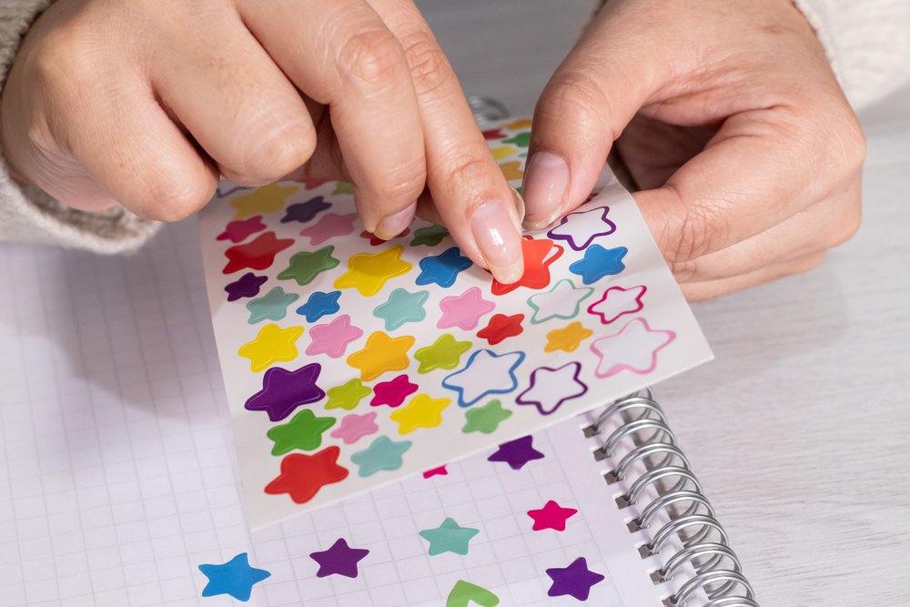 Placing,Tiny,Stickers,In,A,Notebook
