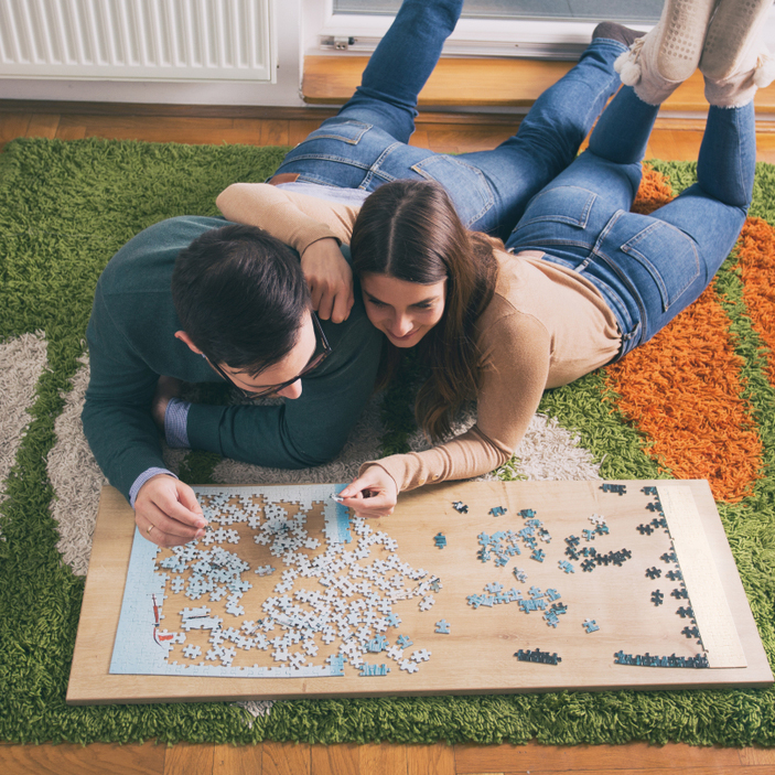 Top,View,Of,Young,Couple,Laying,On,Floor,And,Doing