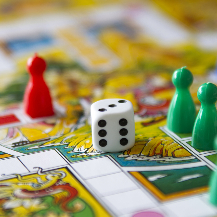 Colorful,Play,Figures,With,Dice,On,Board