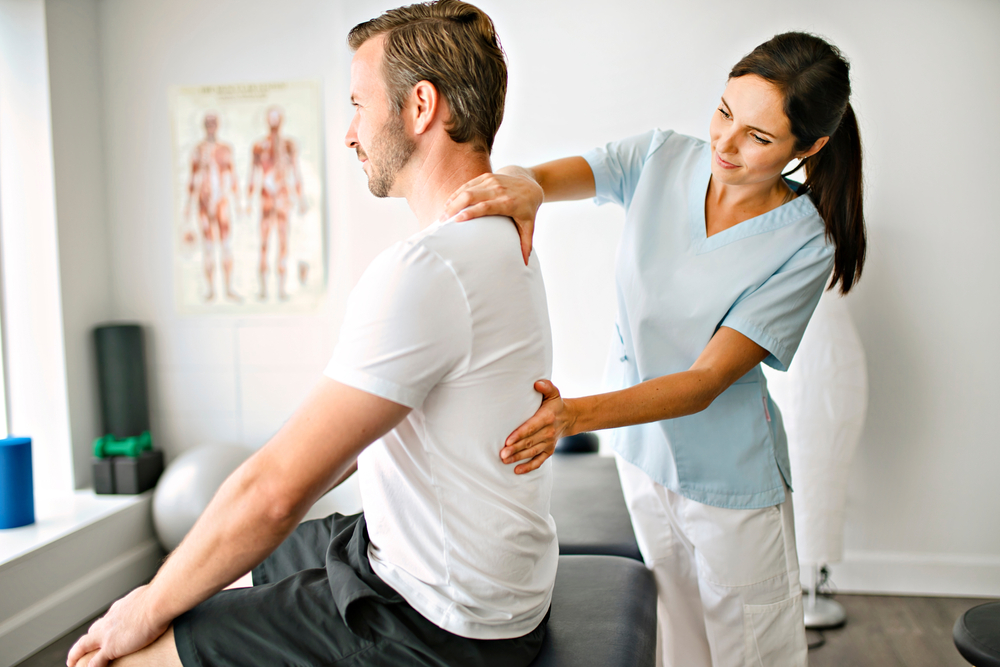 A,Physiotherapist,Doing,Treatment,With,Patient,In,Bright,Office