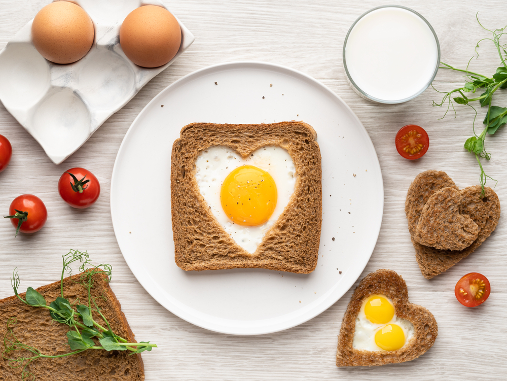 Heart,Shaped,Egg,In,Tosted,Bread,On,White,Ceramic,Plate.