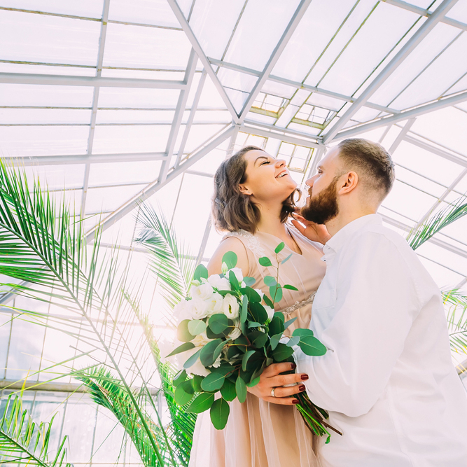 Romantic,Newlywed,Couple,Having,Fun,In,The,Botanical,Garden.,Against