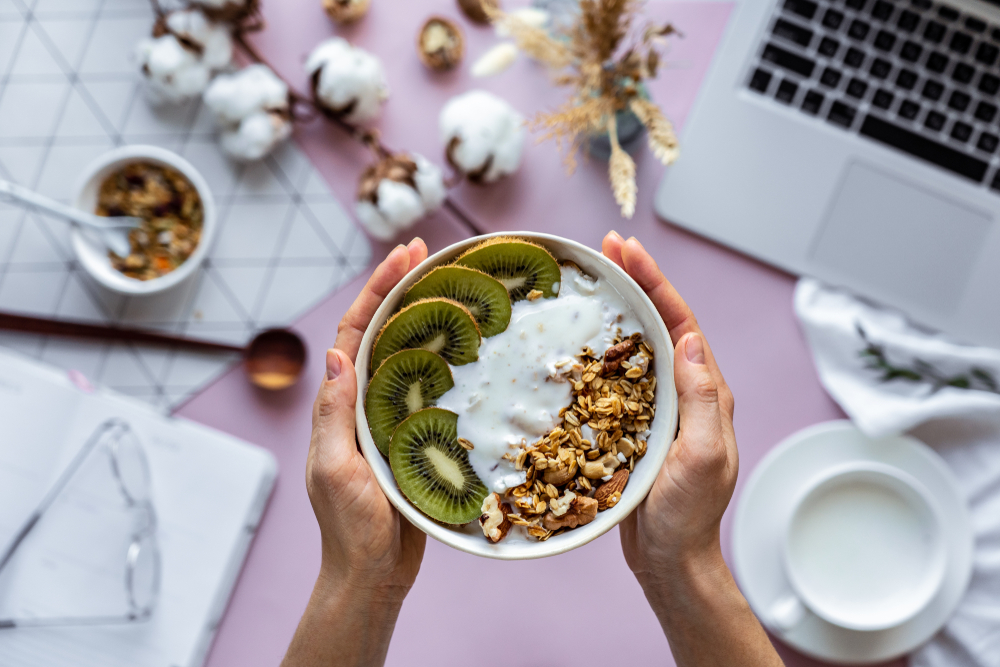 Female,Hand,Holding,Healthy,Breakfast,Bowl,Over,Work,Table,Background