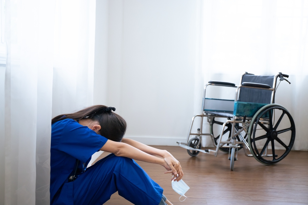 Female,Asian,Nurse,Wears,Face,Mask,Blue,Uniform,Sits,On