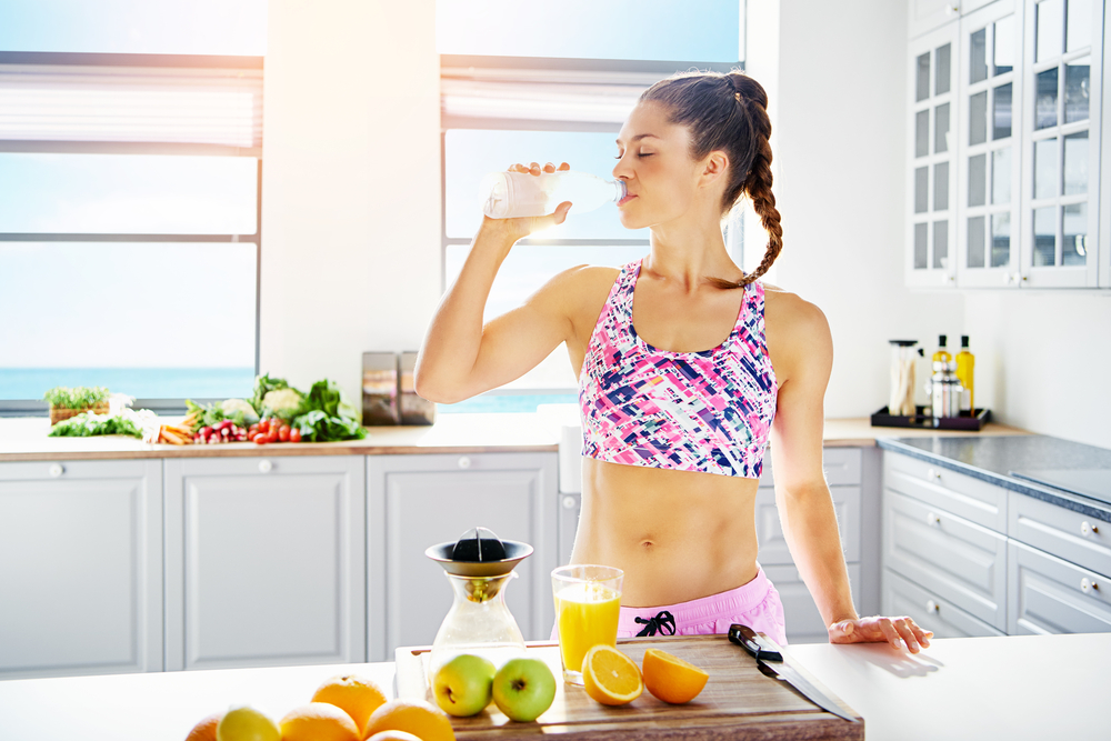 Young,Fit,Woman,In,Sportswear,Drinking,Water,While,Standing,At