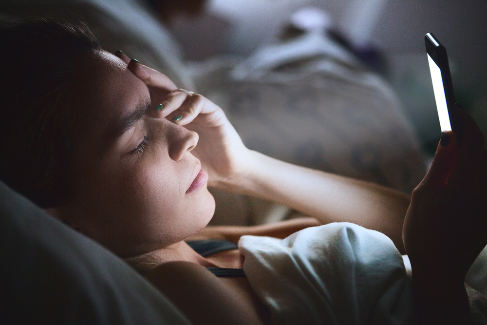 Woman,In,Bed,With,Phone,,Headache