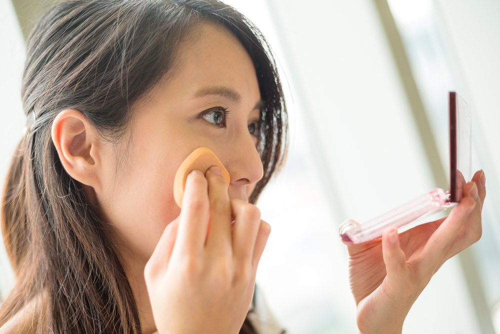 Woman,Using,Powder,To,Touch,Up,On,Her,Face