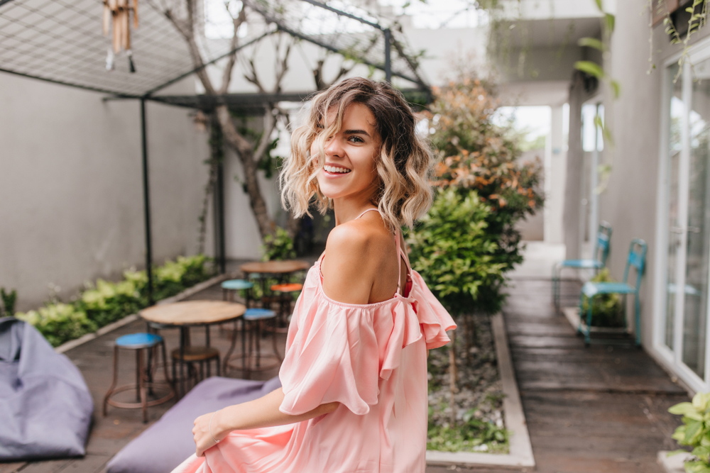 Graceful,Short-haired,Girl,Looking,Over,Shoulder,In,Cozy,Street,Restaurant.