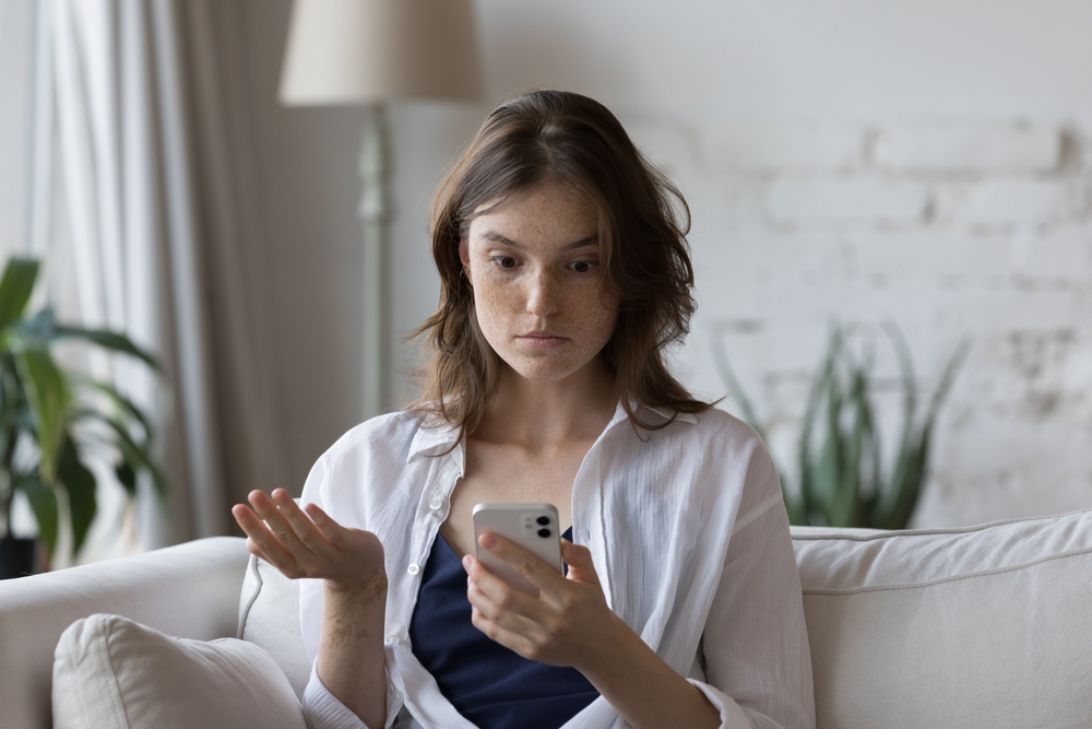 Shocked,Concerned,Cellphone,User,Girl,Staring,At,Screen,,Looking,At