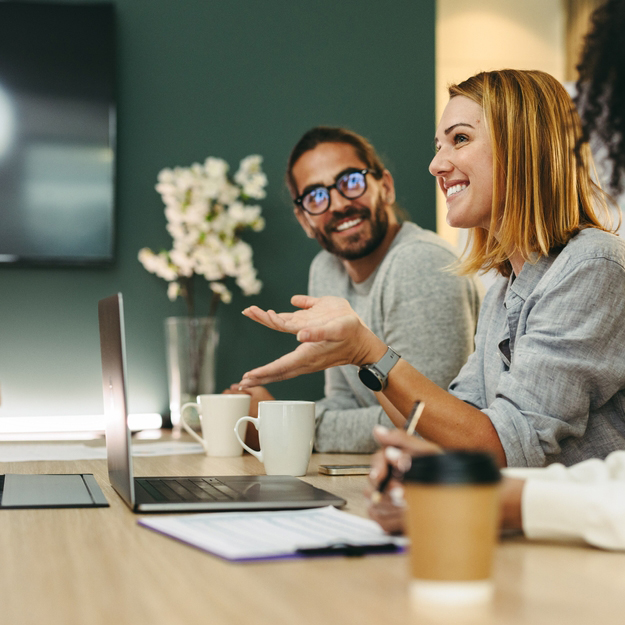 Cheerful,Businesswoman,Having,A,Discussion,With,Her,Colleagues,In,A