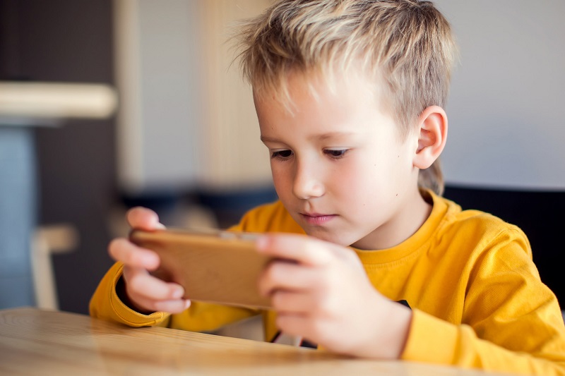 Children, technology and internet concept. Little smiling boy pl