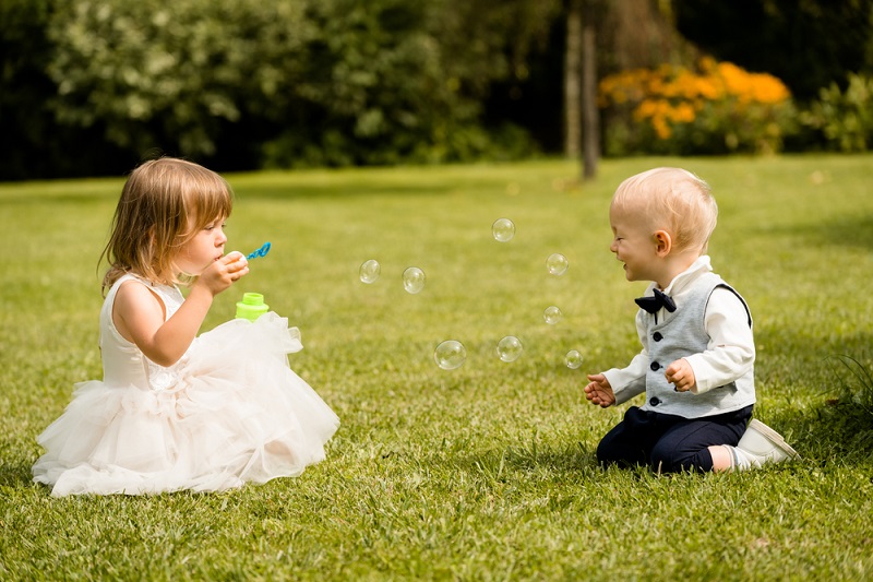 Playful,Children,Blowing,Bubbles,Wand,In,The,Park,On,A