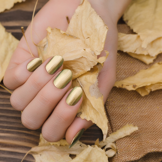 Female,Hands,With,Gold,Chameleon,Nail,Design,Holding,Fallen,Leaves.