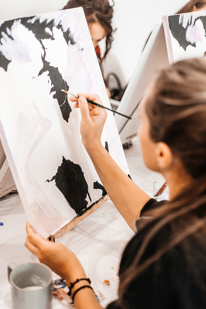 A,Young,Woman,Painstakingly,Draws,Her,Picture,With,Brushes,On