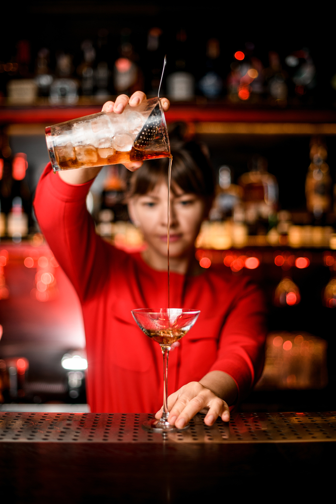 Wineglass,Stands,On,Bar,And,Woman,Bartender,Holds,Mixing,Cup