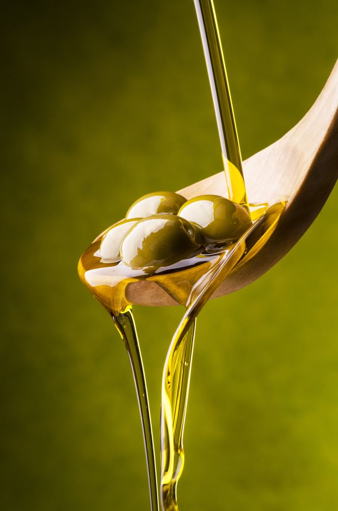 Extra,Virgin,Olive,Oil,Flows,On,A,Wooden,Bowl,Full