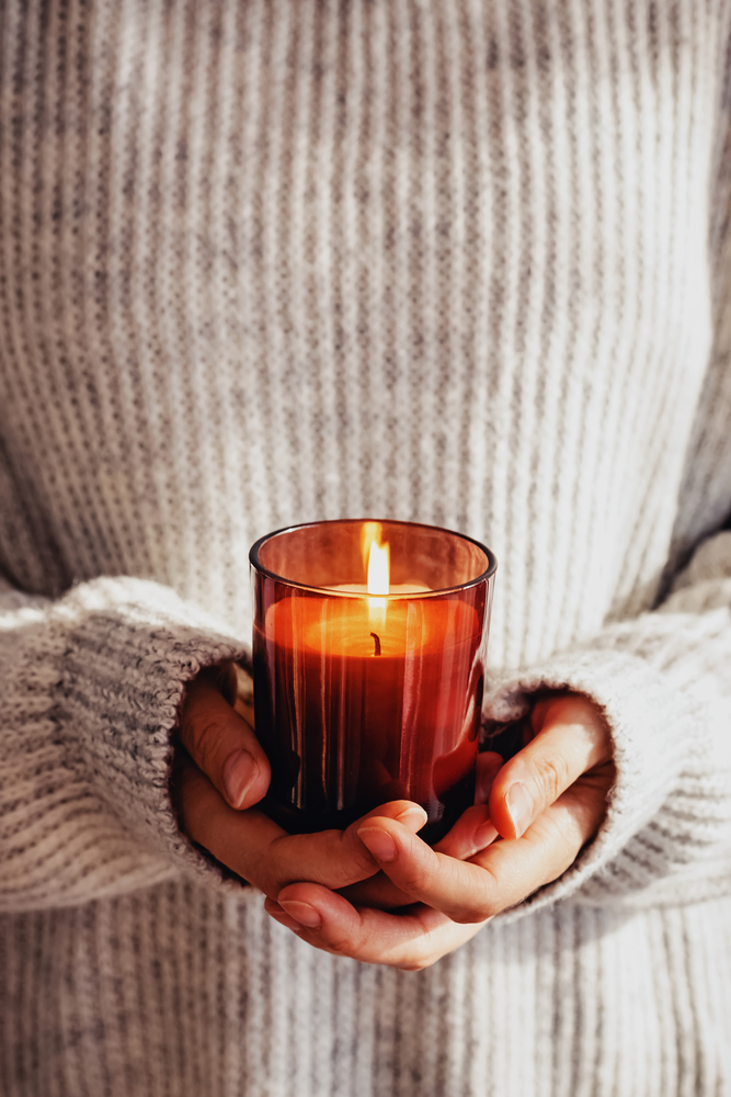 Woman,In,Cozy,Sweater,Holding,Burning,Candle,Close-up.,Cozy,Autumn