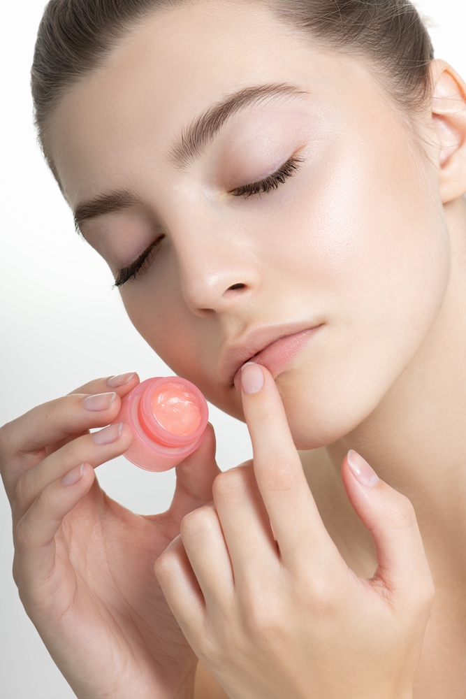 Beautiful,Young,Woman,With,Perfect,Skin,Applies,Lip,Balm.,Portrait