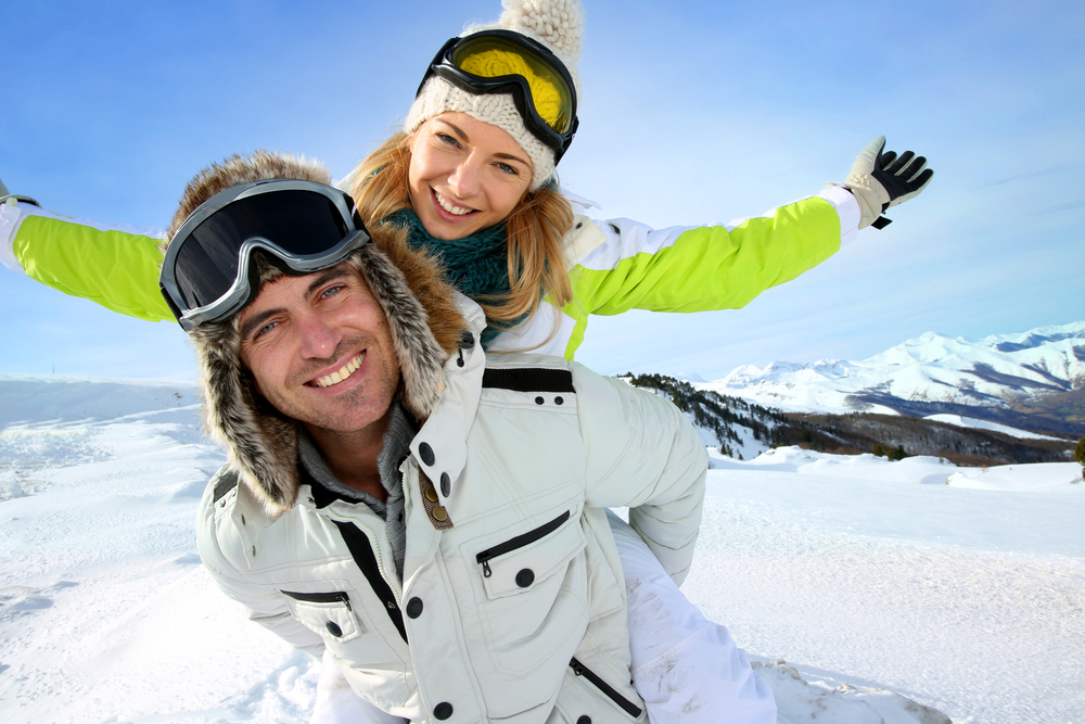 Cheerful,Snowboarder,Holding,Girlfriend,On,His,Back