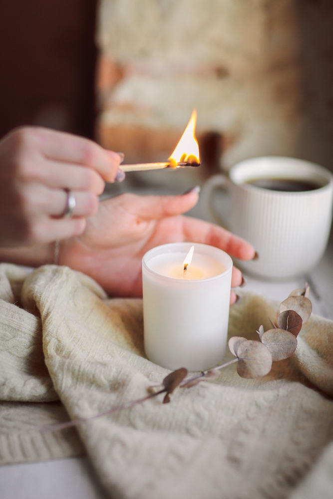 Female,Hands,With,Lit,Match,Lighting,Burning,Candle,On,Windowsill