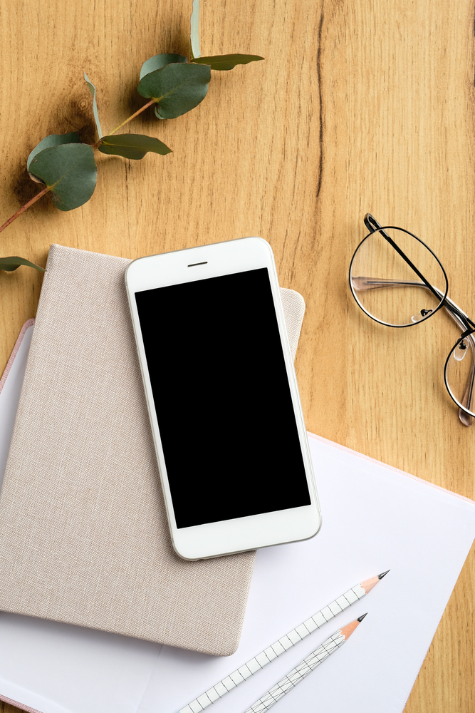 Wood,Office,Table,With,White,Smartphone,With,Blank,Mockup,Screen,