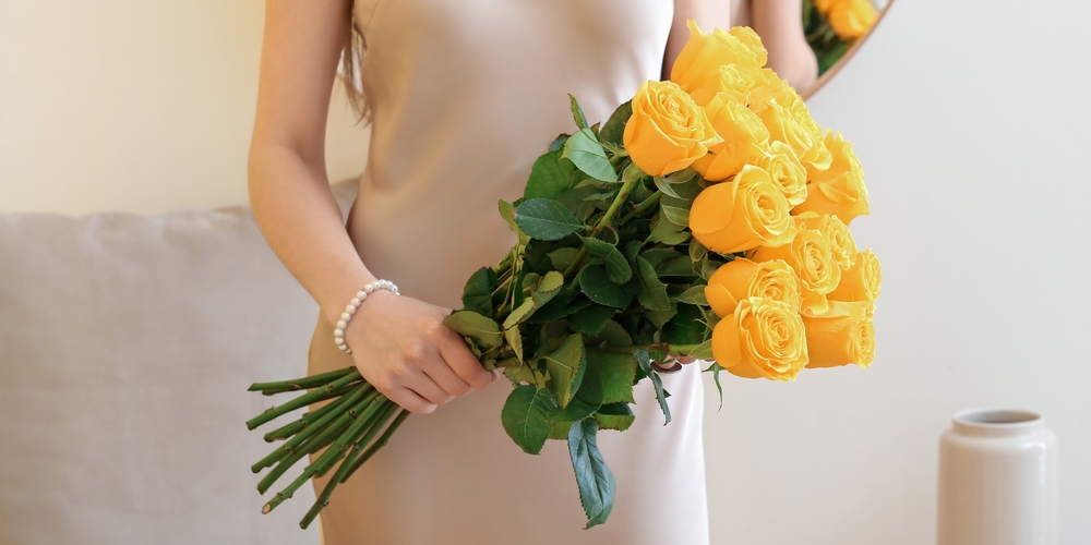 Young,Woman,With,Beautiful,Yellow,Roses,In,Room,,Closeup