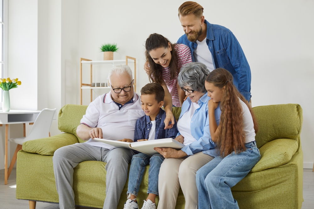 Family,Looks,At,Photo,Album,Together,And,Remembers,Stories,From