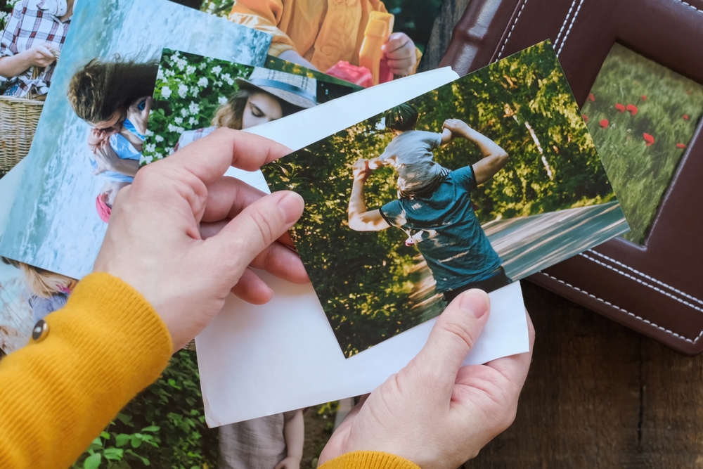Person,Looks,At,Printed,Photos,For,Family,Photo,Album.,Overhead